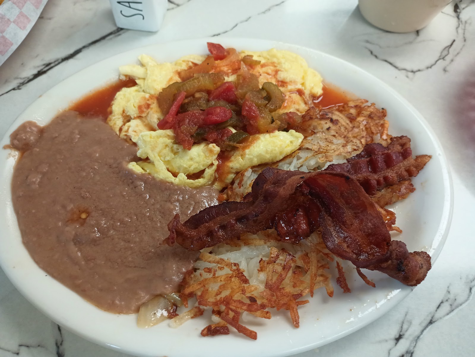 Breakfast plate with eggs, hash browns and bacon